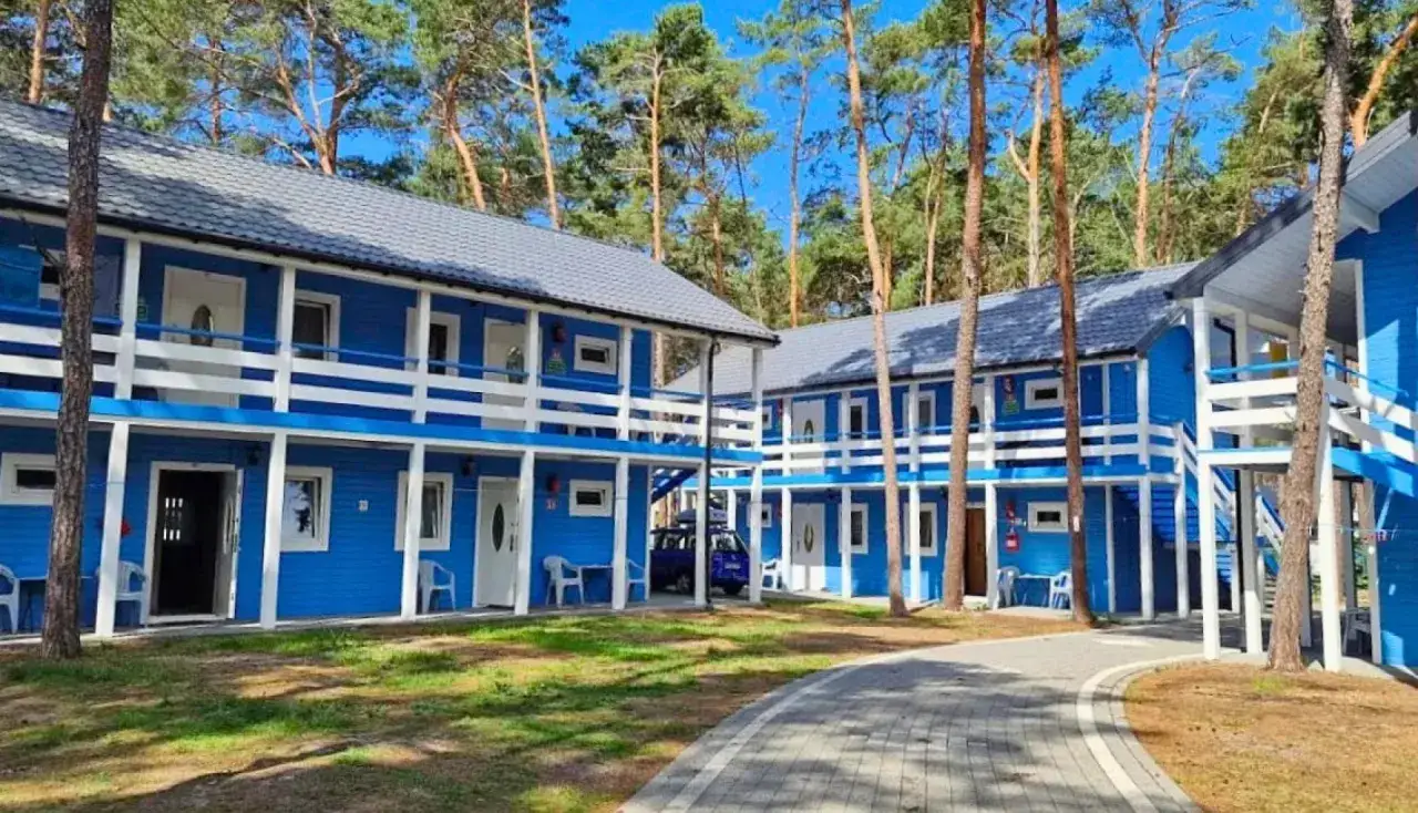 Niebieskie domki letniskowe w lesie, idealne na dziwnów noclegi blisko morza. Dostępne pokoje na parterze i piętrze z balkonami.