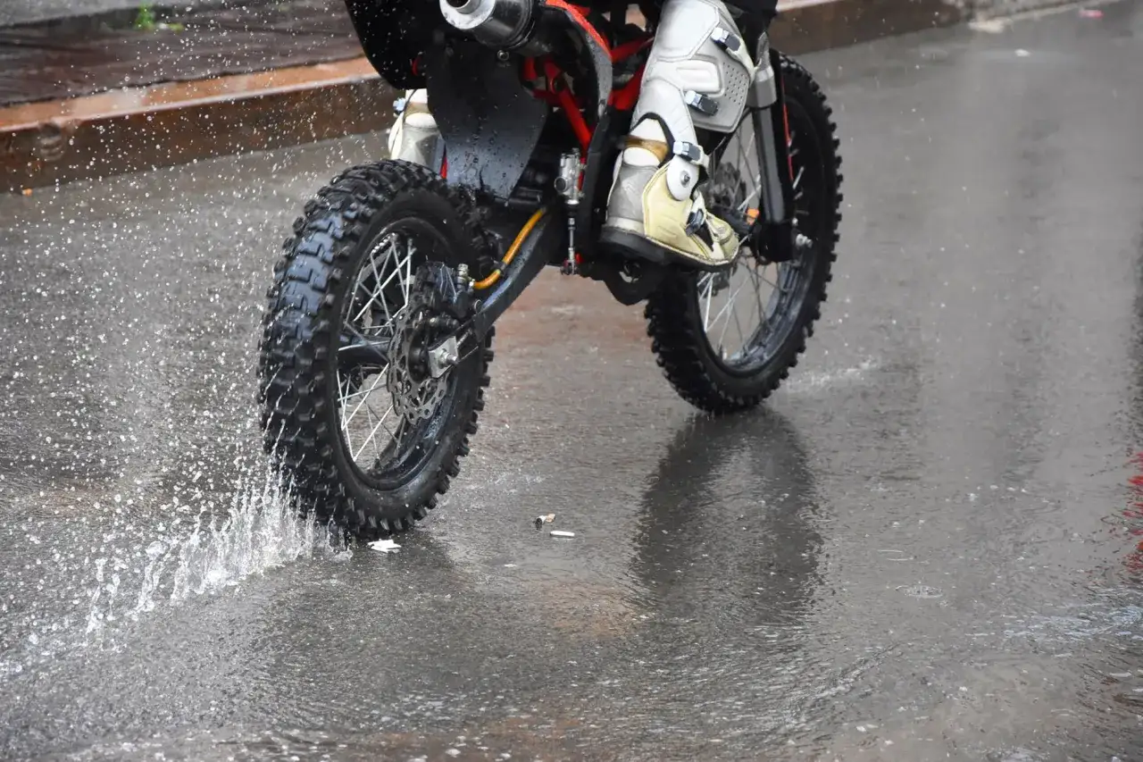 Niezwykła jazda motocyklem w deszczu. Błoto i woda rozpryskują się spod kół, tworząc widowiskowy pokaz.