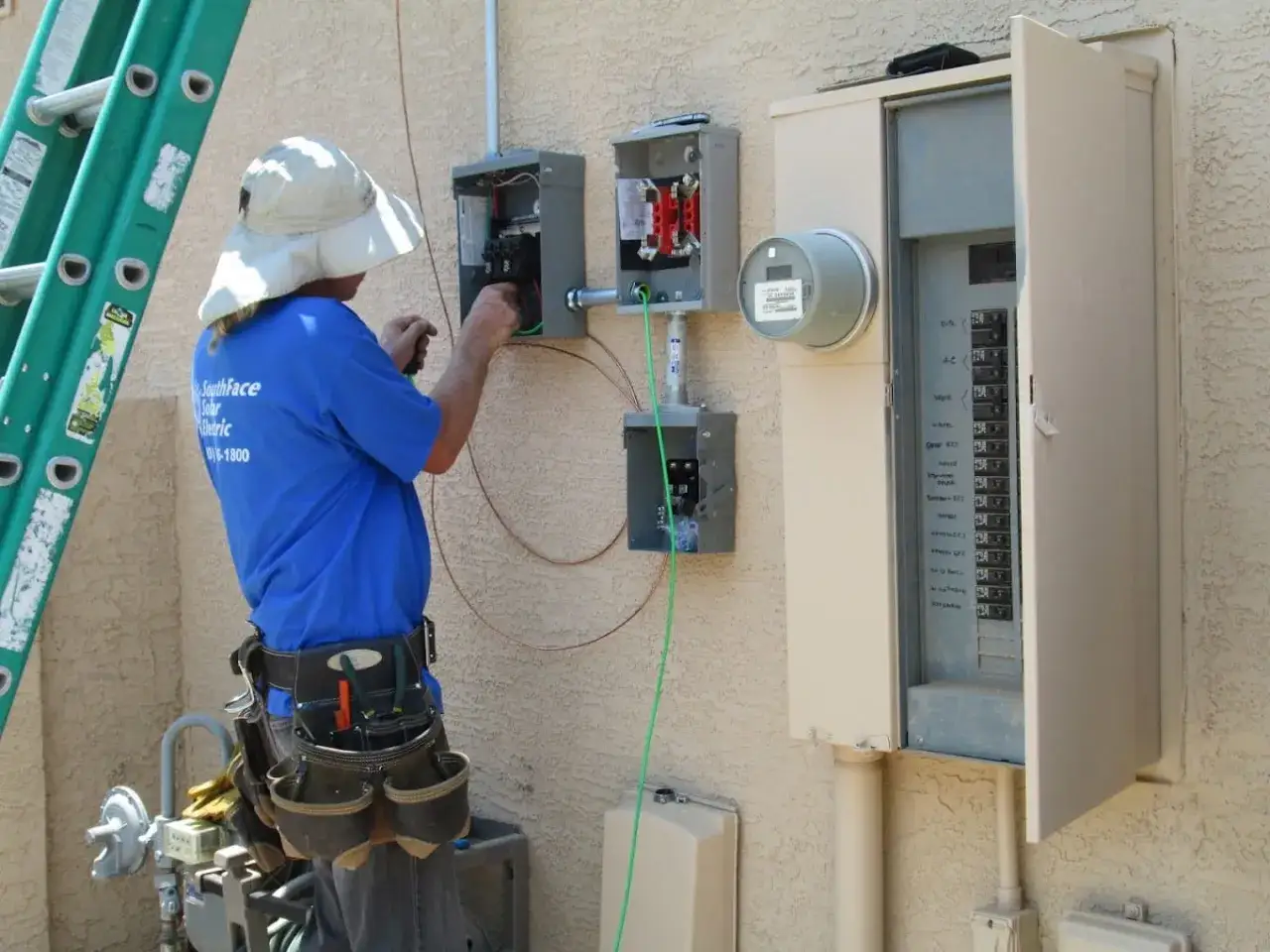Elektryk pracuje przy skrzynce elektrycznej, podłączając przewody. To kluczowy etap instalacji, który określa moc przyłączeniową.