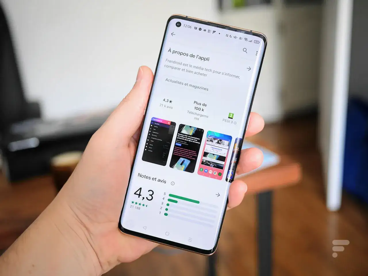 Main tenant un smartphone Samsung, affichant la page d'une application sur le Play Store, prêt à mettre à jour une application.