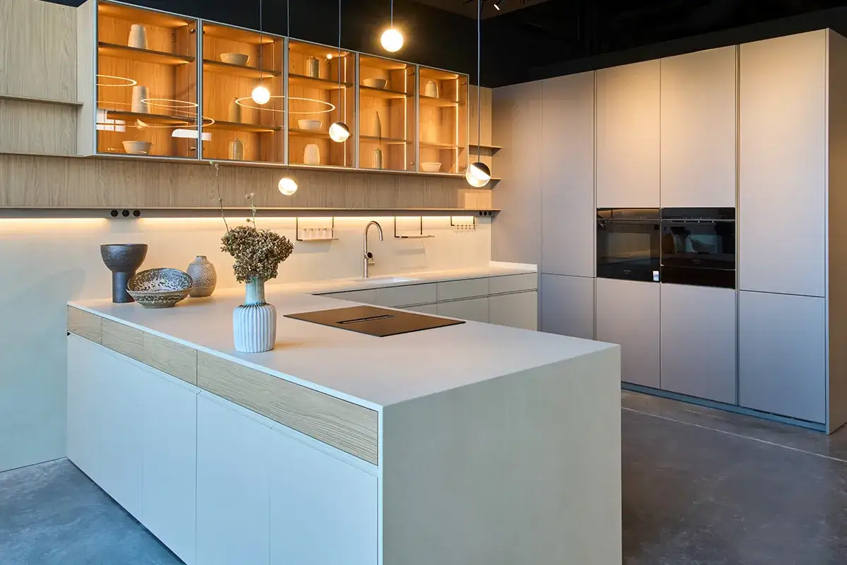 Cocina moderna con isla central, gabinetes de madera y acero inoxidable, y hornos integrados. Diseños cocinas minimalistas y elegantes.