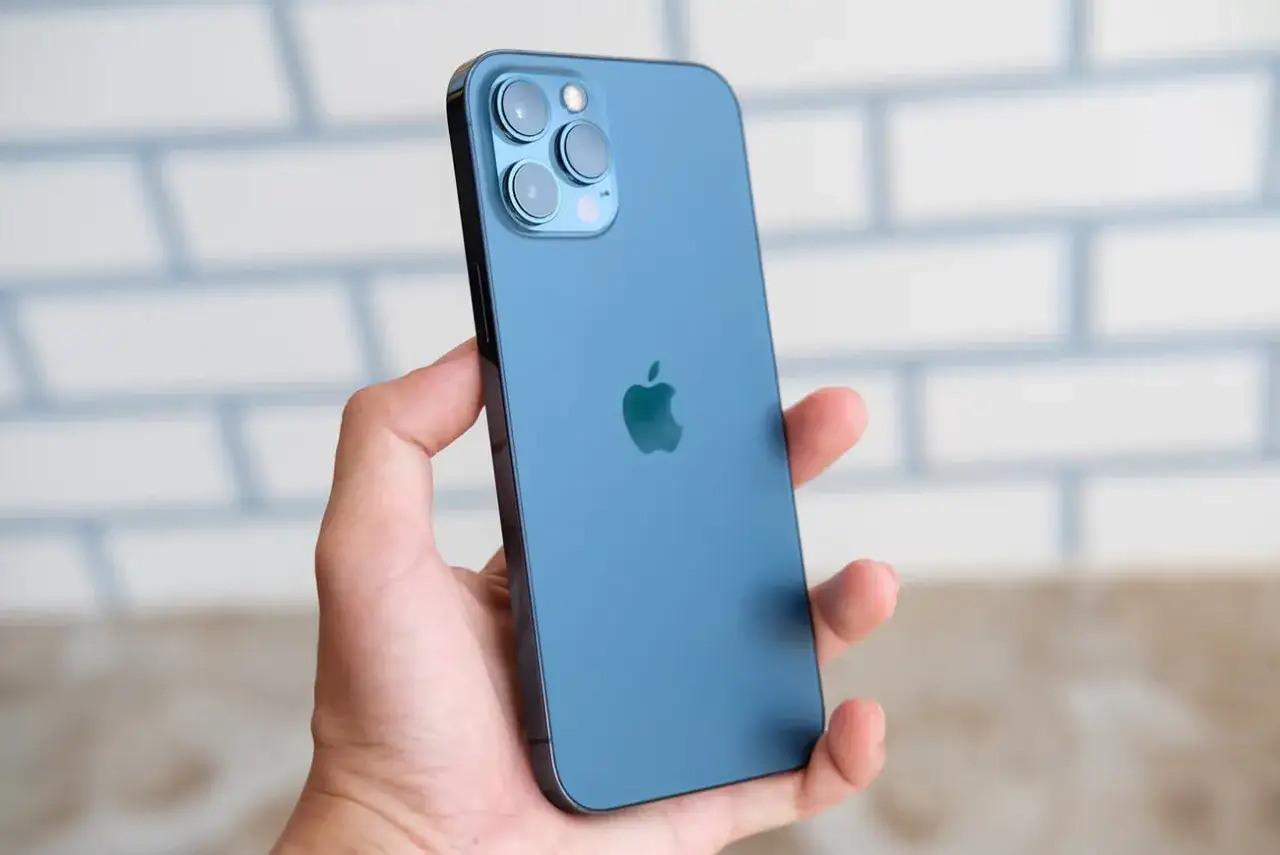 Main bleue, triple appareil photo, logo Apple. Les iphone 12 spécifications techniques sont impressionnantes.