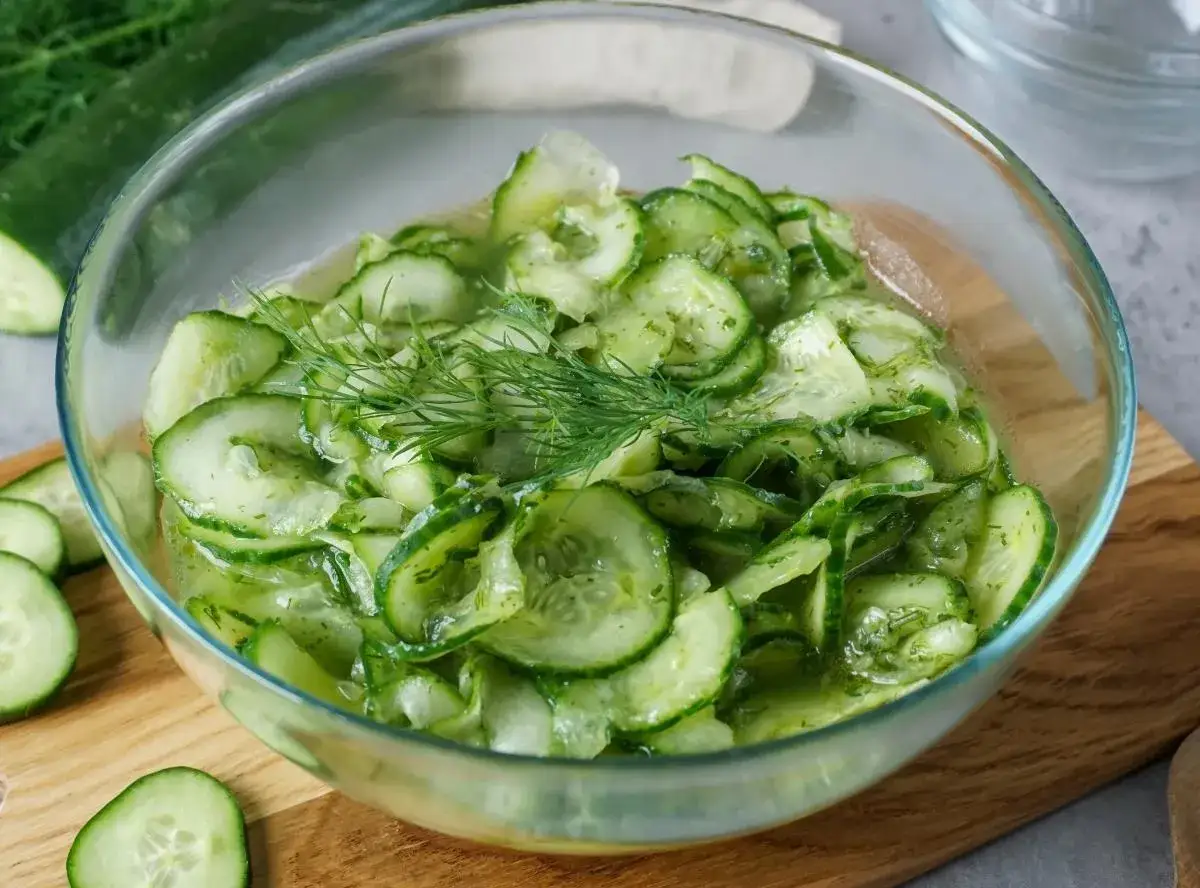 Frischer gurkensalat wie bei Oma, mit Dill garniert, in einer Glasschüssel.
