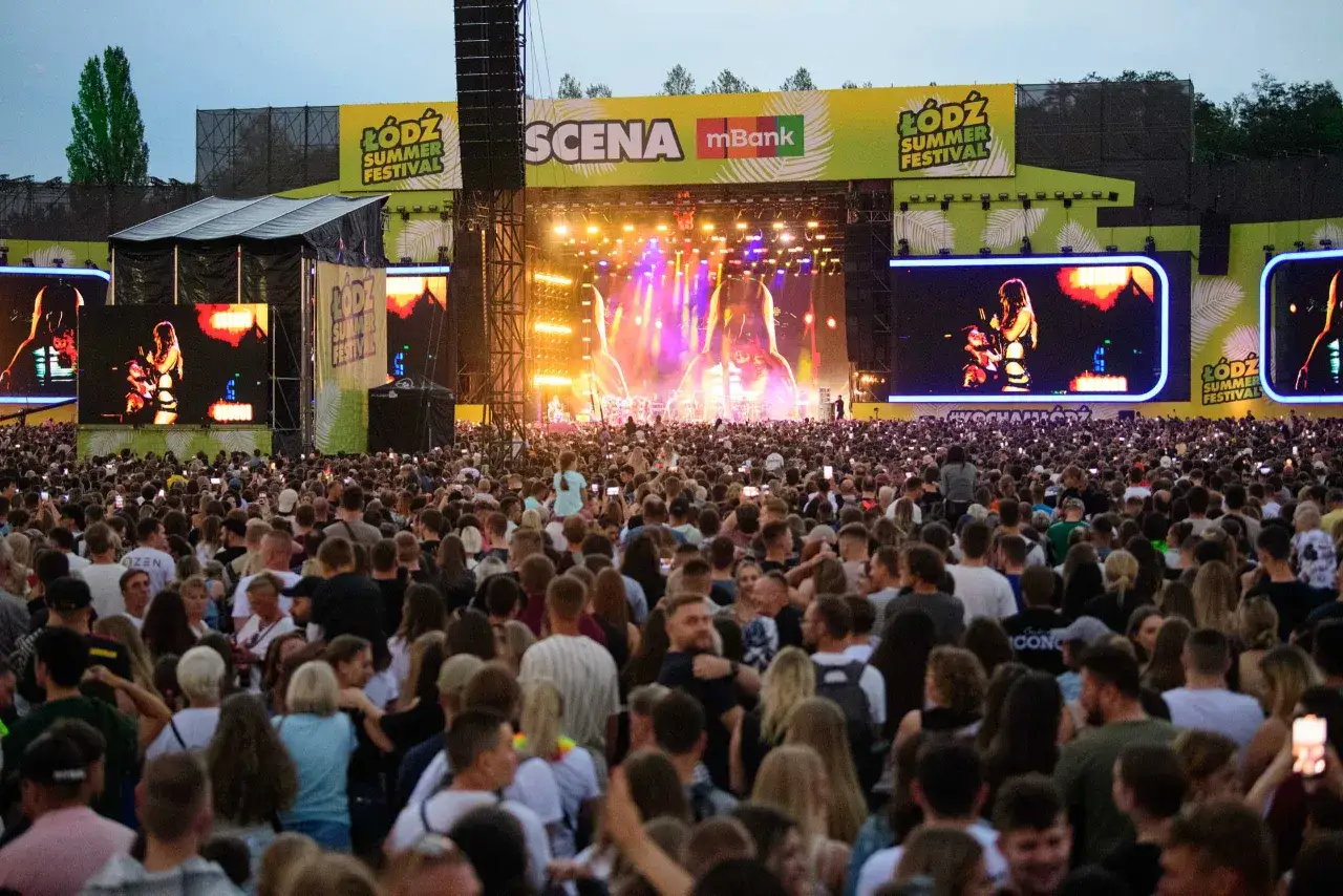 Tłum ludzi na koncercie podczas Łódź Summer Festival. Na scenie artystka, a nad nią wielkie ekrany z jej wizerunkiem.