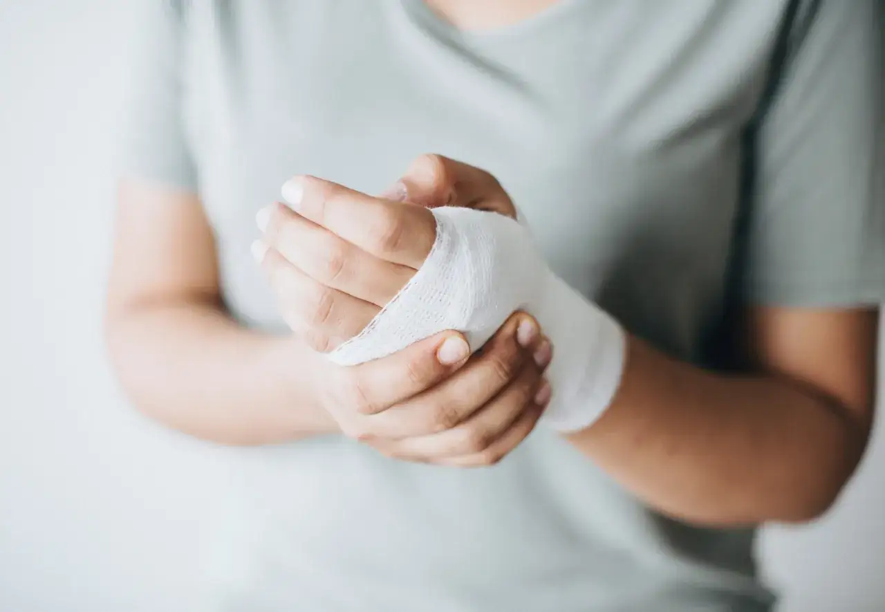 Dłoń z bandażem, wspierająca proces gojenia ran. Odpowiednia dieta na gojenie ran przyspieszy powrót do zdrowia.