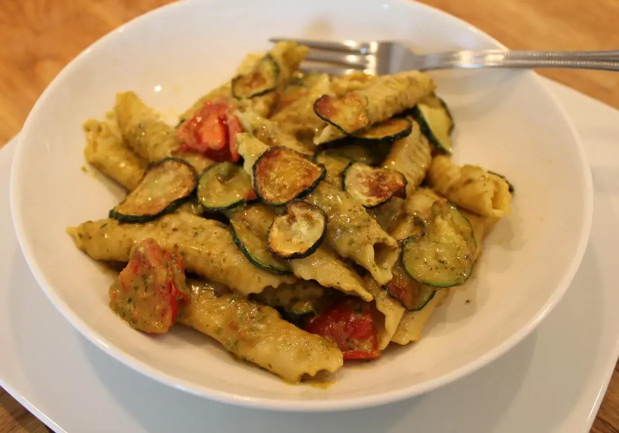 Pyszne makaron garganelli z cukinią i pomidorkami w sosie pesto.