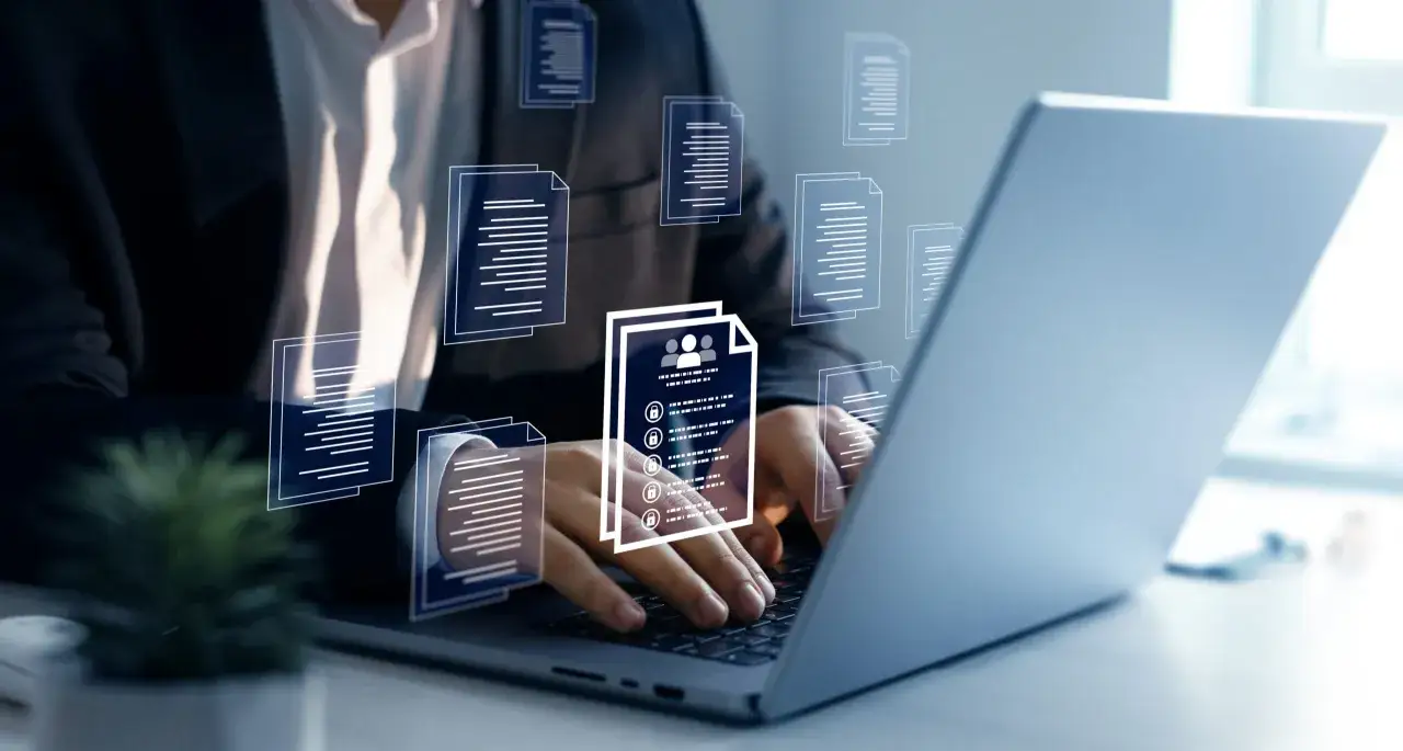 Biznesmen pracuje przy laptopie, przeglądając dokumenty. Wirtualne ikony dokumentów unoszą się wokół, symbolizując zarządzanie danymi. Kto to mocodawca? To ten, kto zleca zadanie.