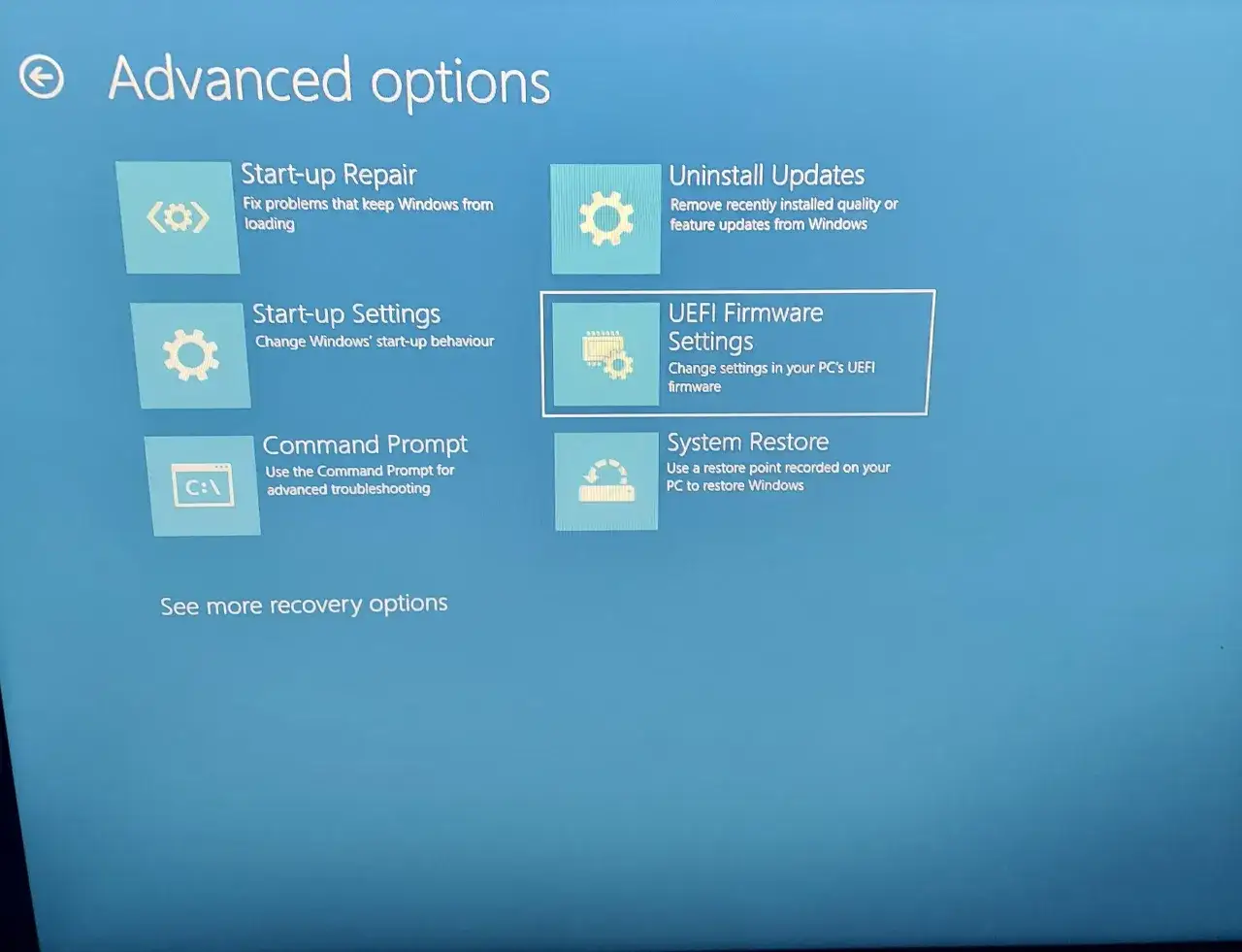 Ekran zaawansowanych opcji odzyskiwania systemu Windows. Widoczne opcje to: Naprawa systemu, Odinstaluj aktualizacje, Ustawienia uruchamiania, Ustawienia oprogramowania układowego UEFI (BIOS), Wiersz polecenia i Przywracanie systemu.