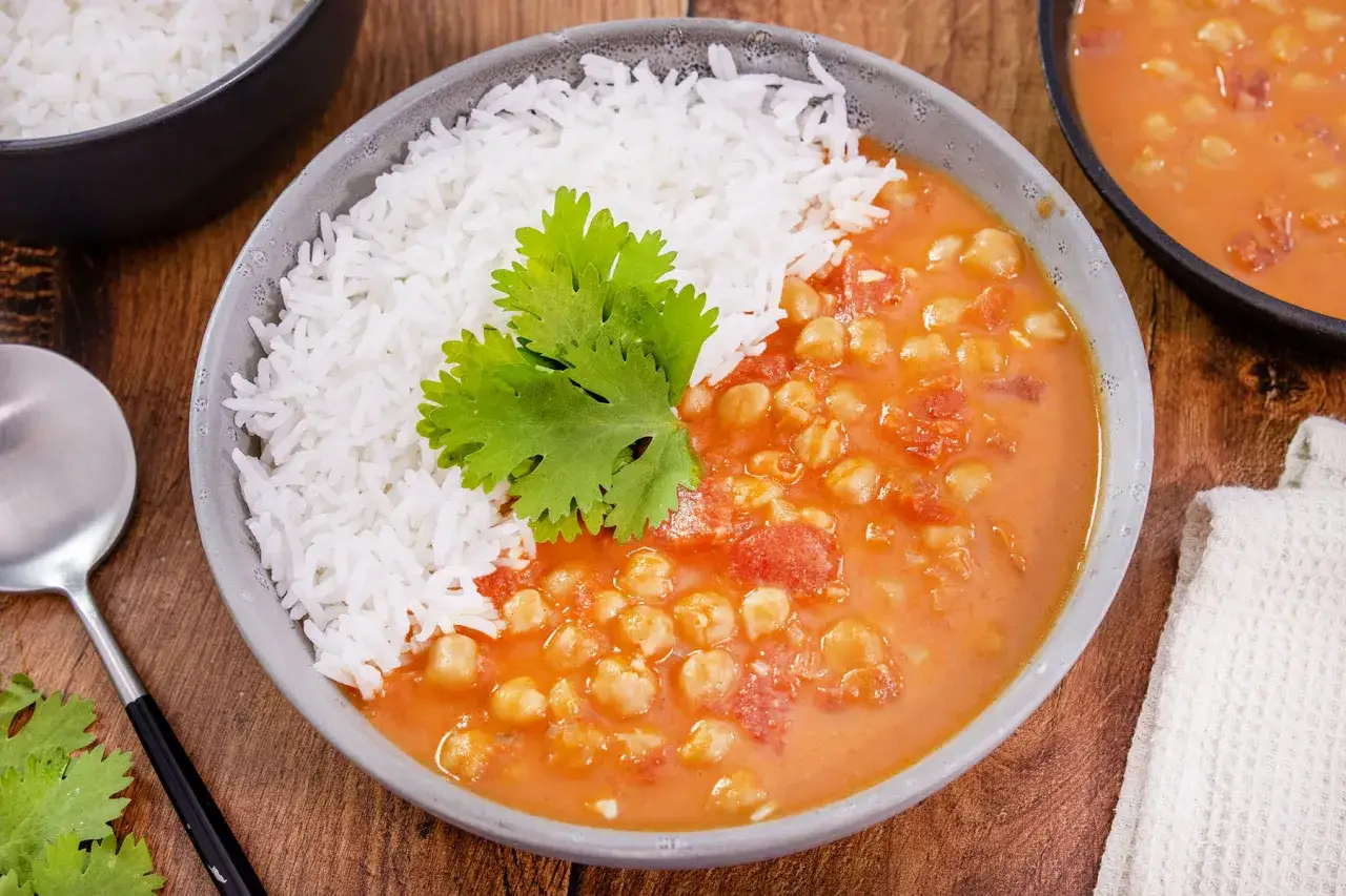 Herzhaftes veganes Kichererbsen-Curry mit Basmatireis, garniert mit Koriander. Ein köstliches Gericht für jeden Tag.