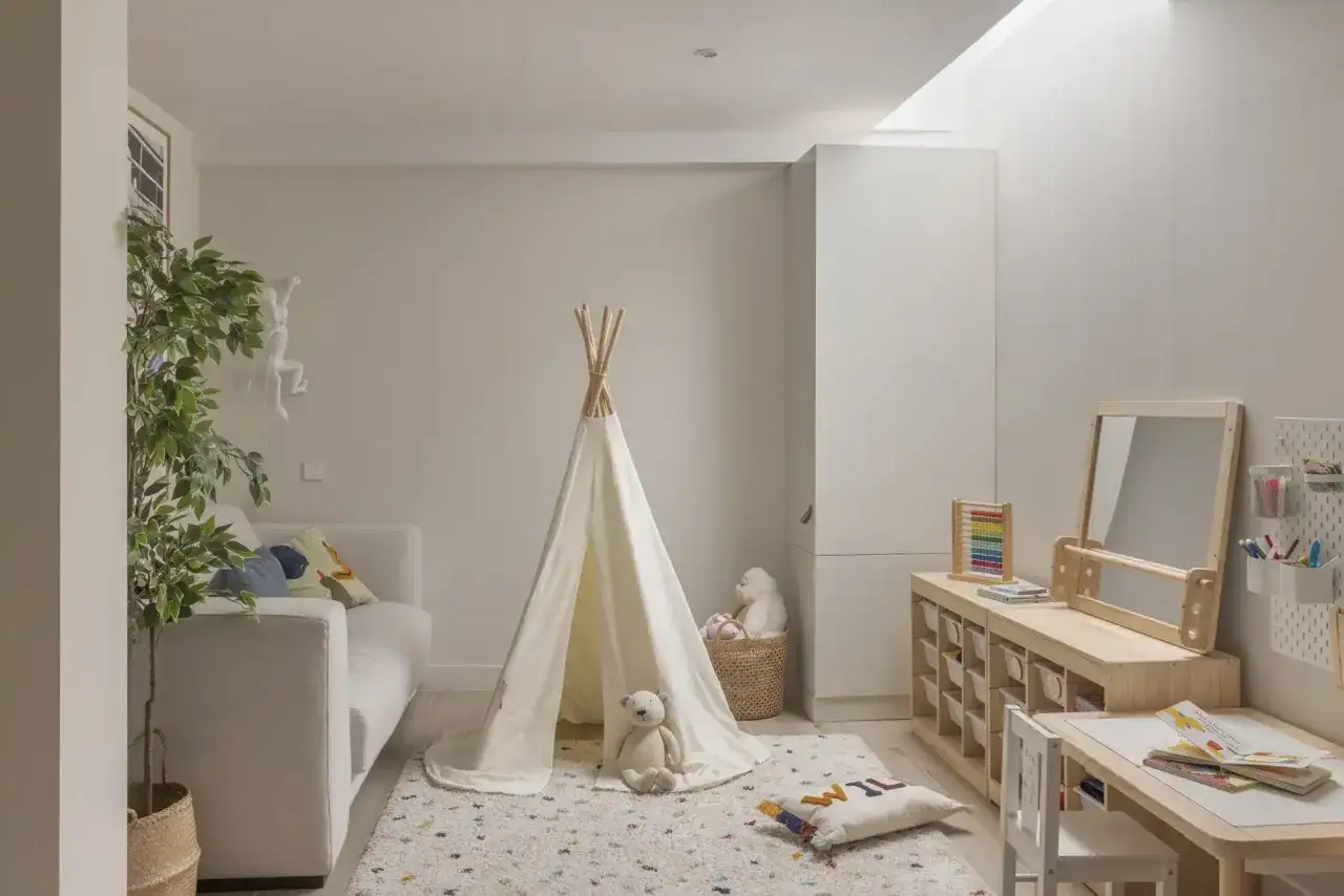 Ideas para un cuarto de juegos: tienda de campaña, sofá, alfombra, mesa de actividades y estanterías de madera.