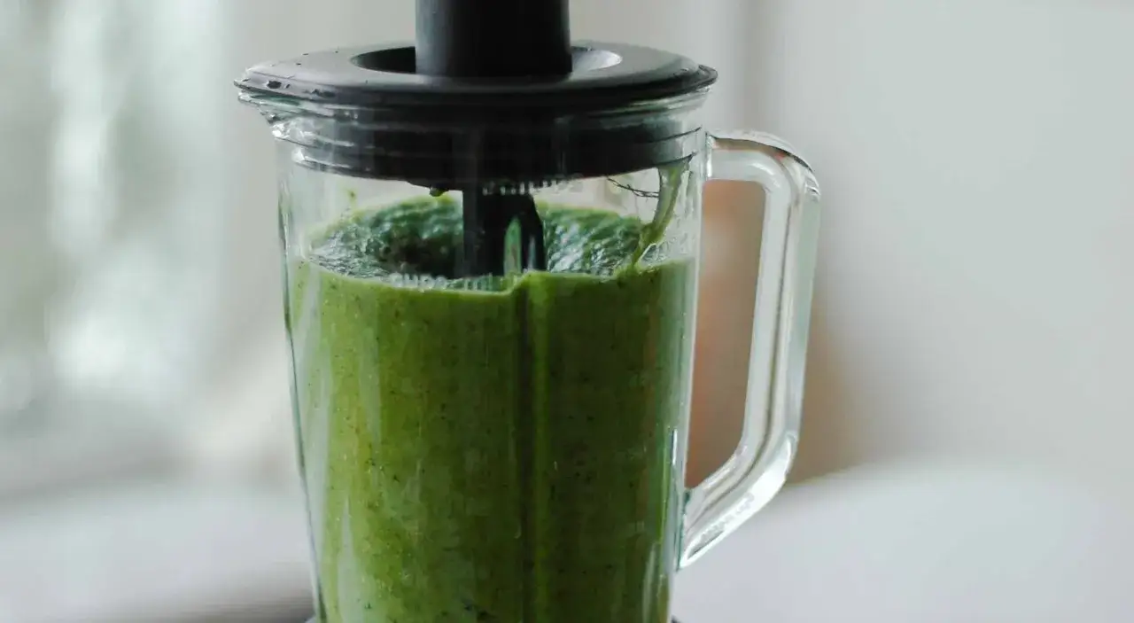 Ein grüner Smoothie wird im Mixer zubereitet. Dieses grüne Saft Rezept ist voller Vitamine.