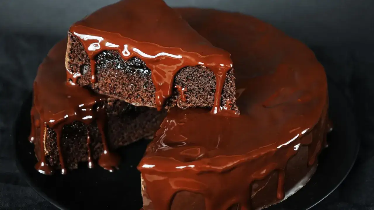 Saftiger Schokokuchen mit glänzender Schokoladenglasur, der wie von Zauberhand im Thermomix entstanden ist.