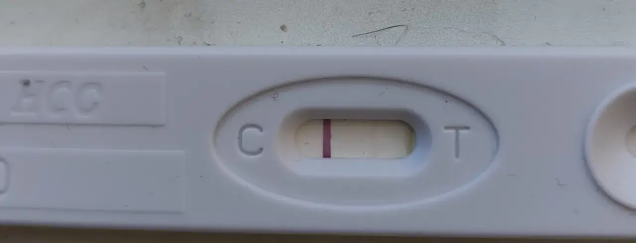 Test ciążowy z widocznym zarysem drugiej kreski. Czekam na cud.
