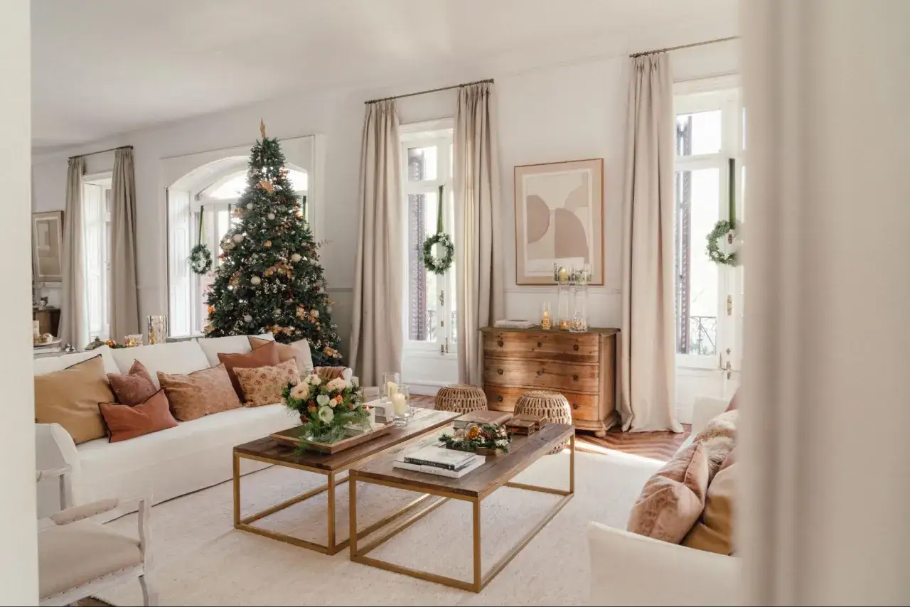 Un salón acogedor con un árbol de Navidad decorado, sofás cómodos y mesas de centro de madera. Es la casa de navidad de el mueble, lista para celebrar.