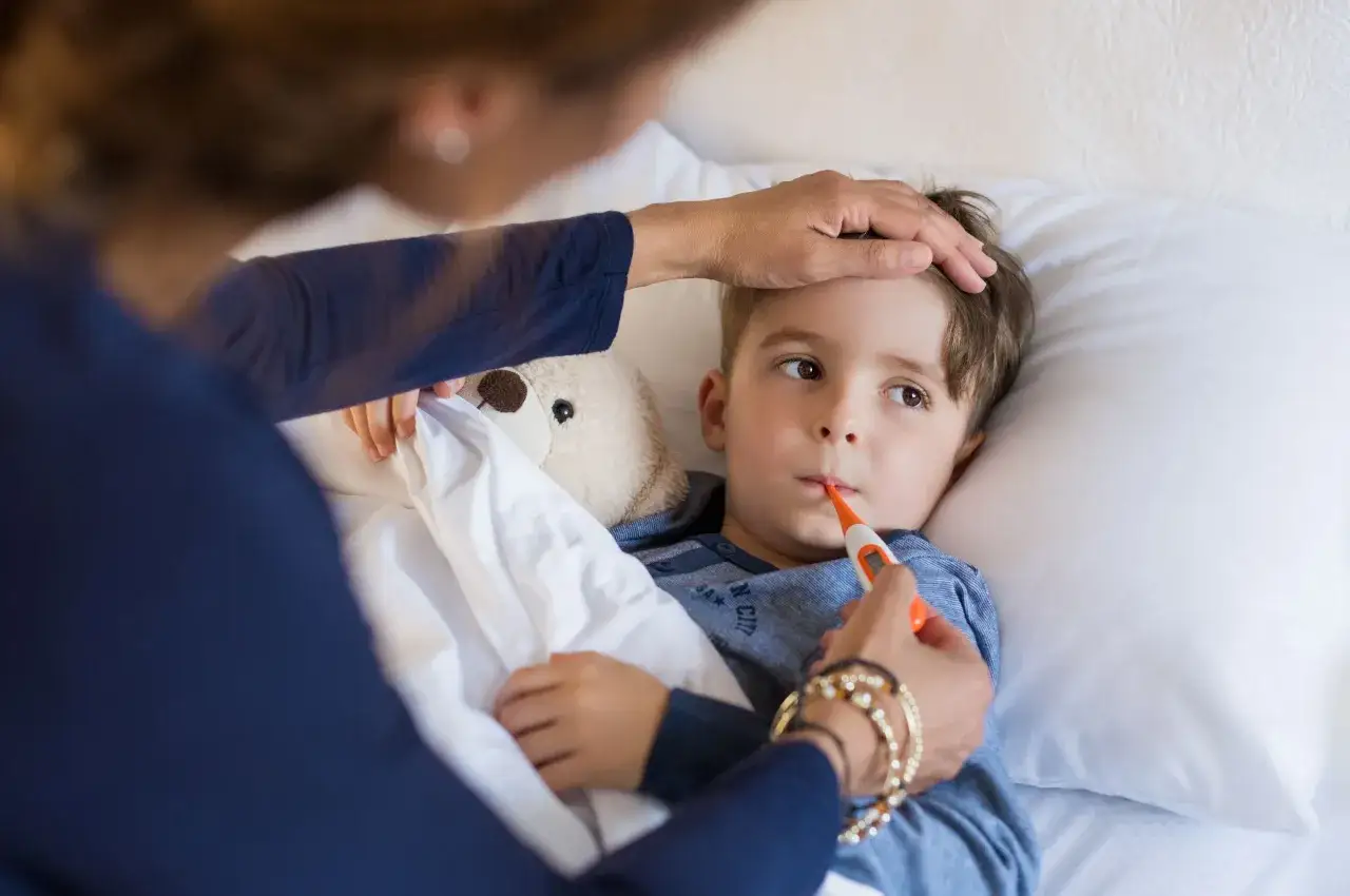 Mama mierzy temperaturę choremu synkowi. Czy można kąpać dziecko gdy ma gorączkę?