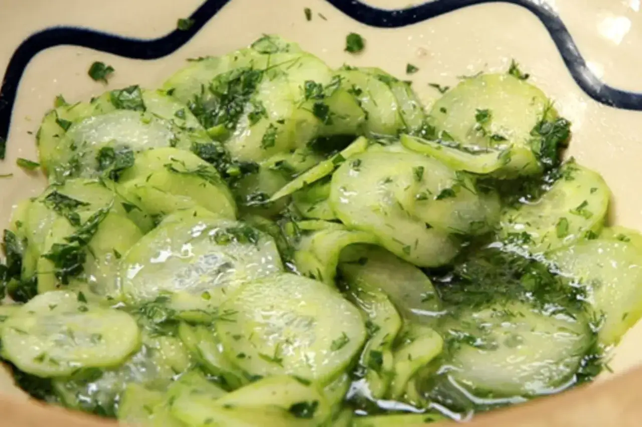 Frischer Gurkensalat ohne Essig, mit Dill und Petersilie, in einer Schüssel serviert.