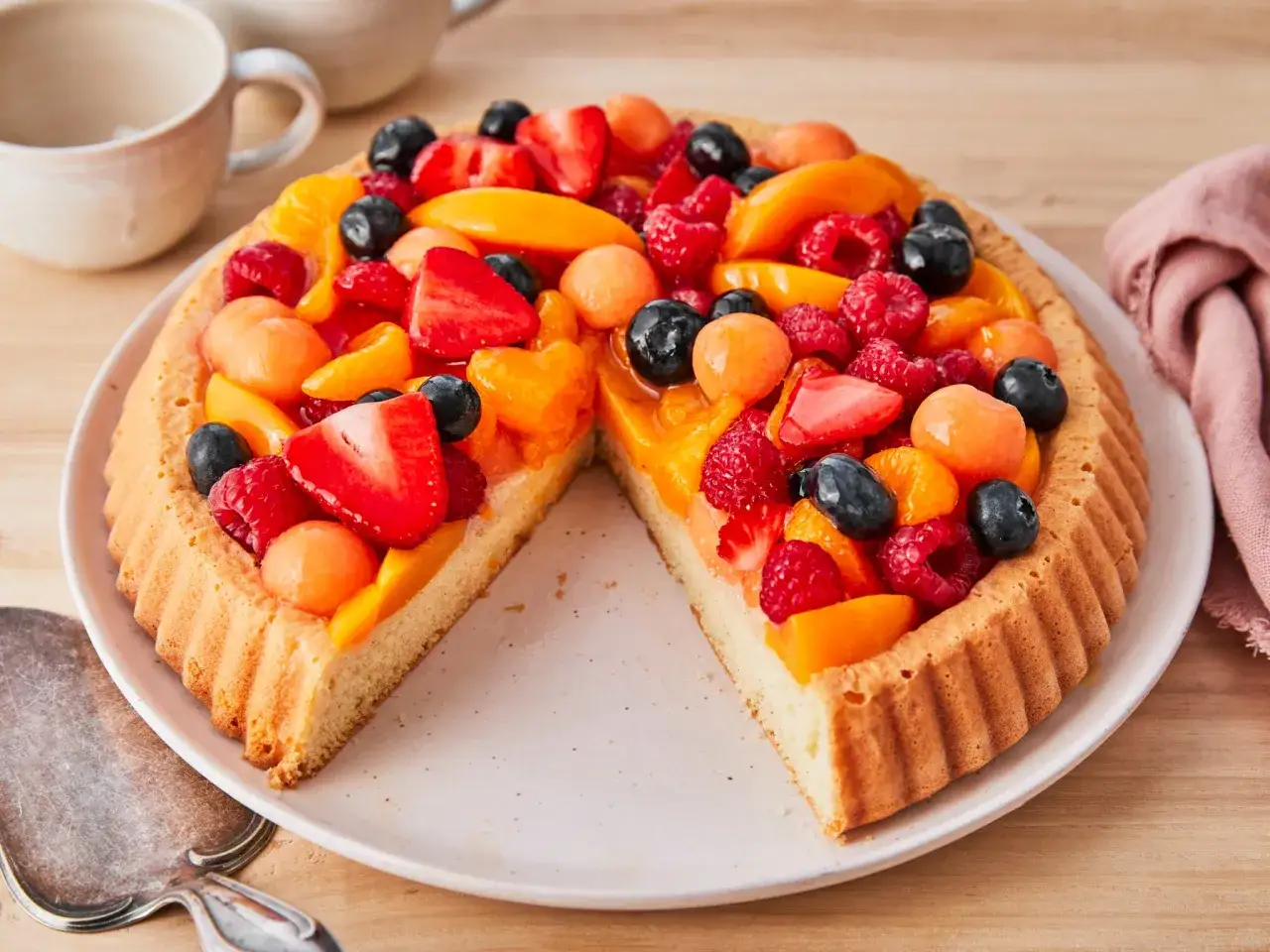 Bunter Obstboden mit Erdbeeren, Himbeeren, Blaubeeren und Aprikosen. Ein köstliches obstboden rezept für den Sommer.