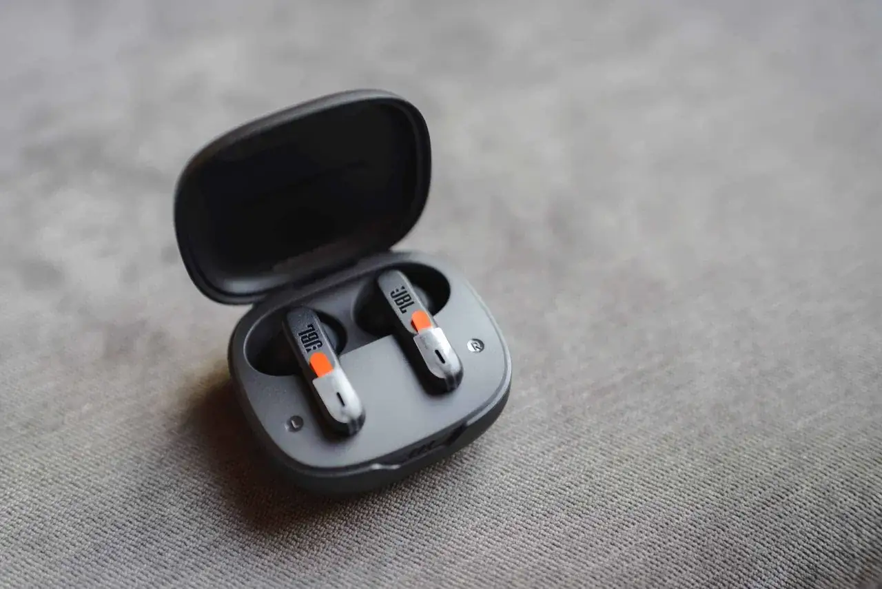 Écouteurs sans fil JBL dans leur étui ouvert. Apprenez comment connecter des écouteurs sans fil à une tablette pour une expérience audio immersive.