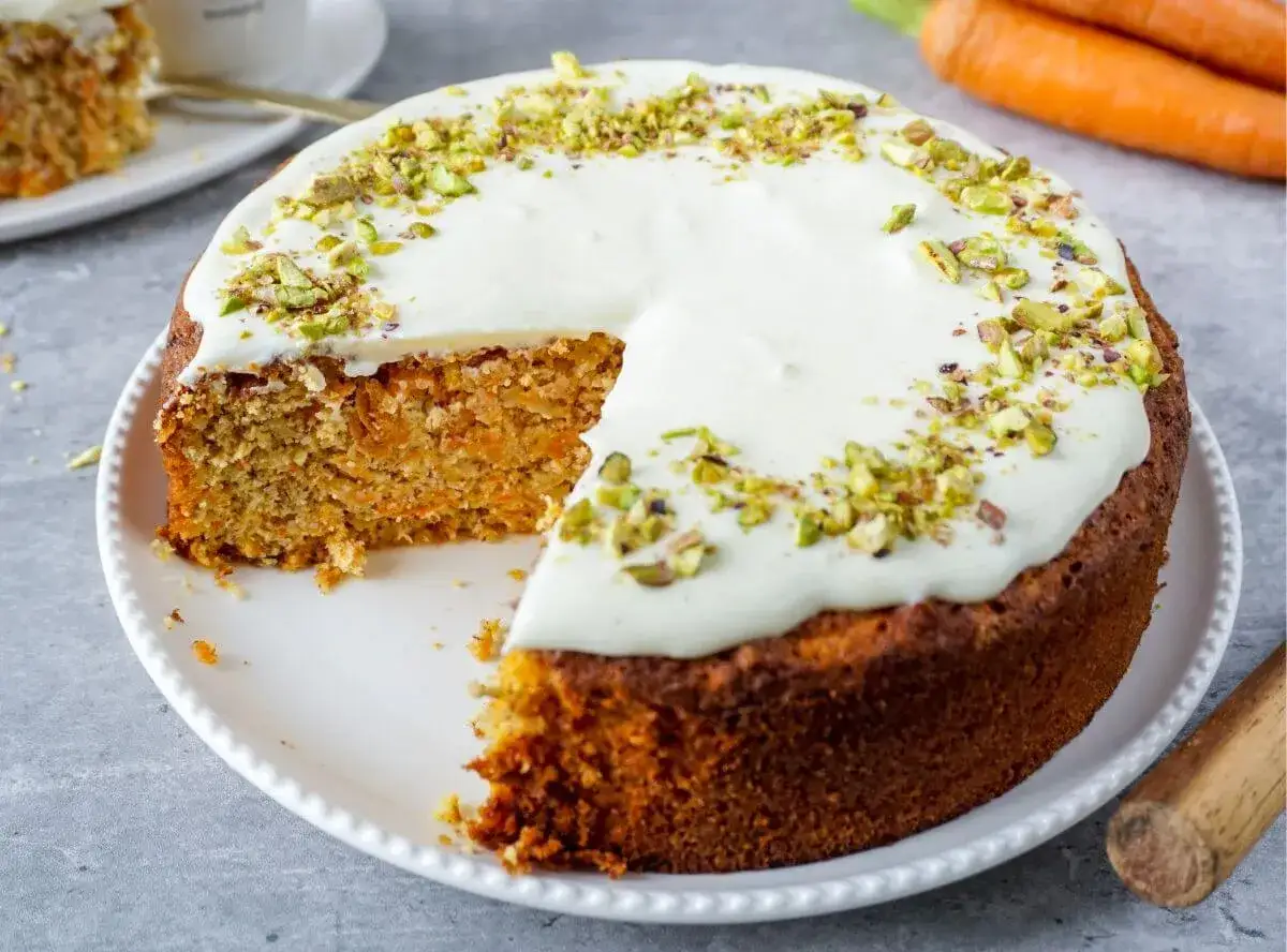 Saftiger Karottenkuchen mit Frischkäse-Frosting und Pistazien. Ein köstliches Beispiel für low carb backrezepte, das Genuss ohne Reue verspricht.