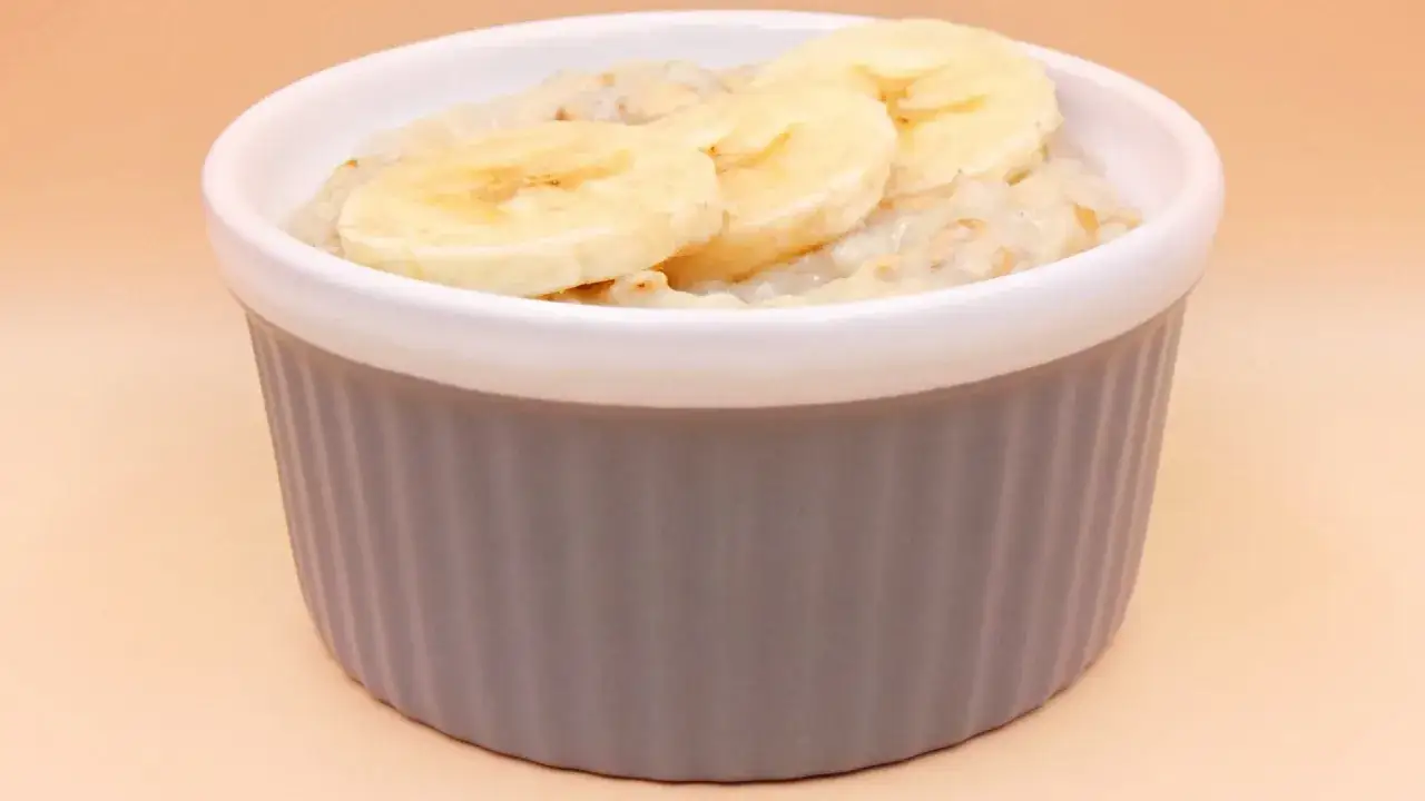Pyszna owsianka z bananem w szarej miseczce, idealna na zdrowe śniadanie.