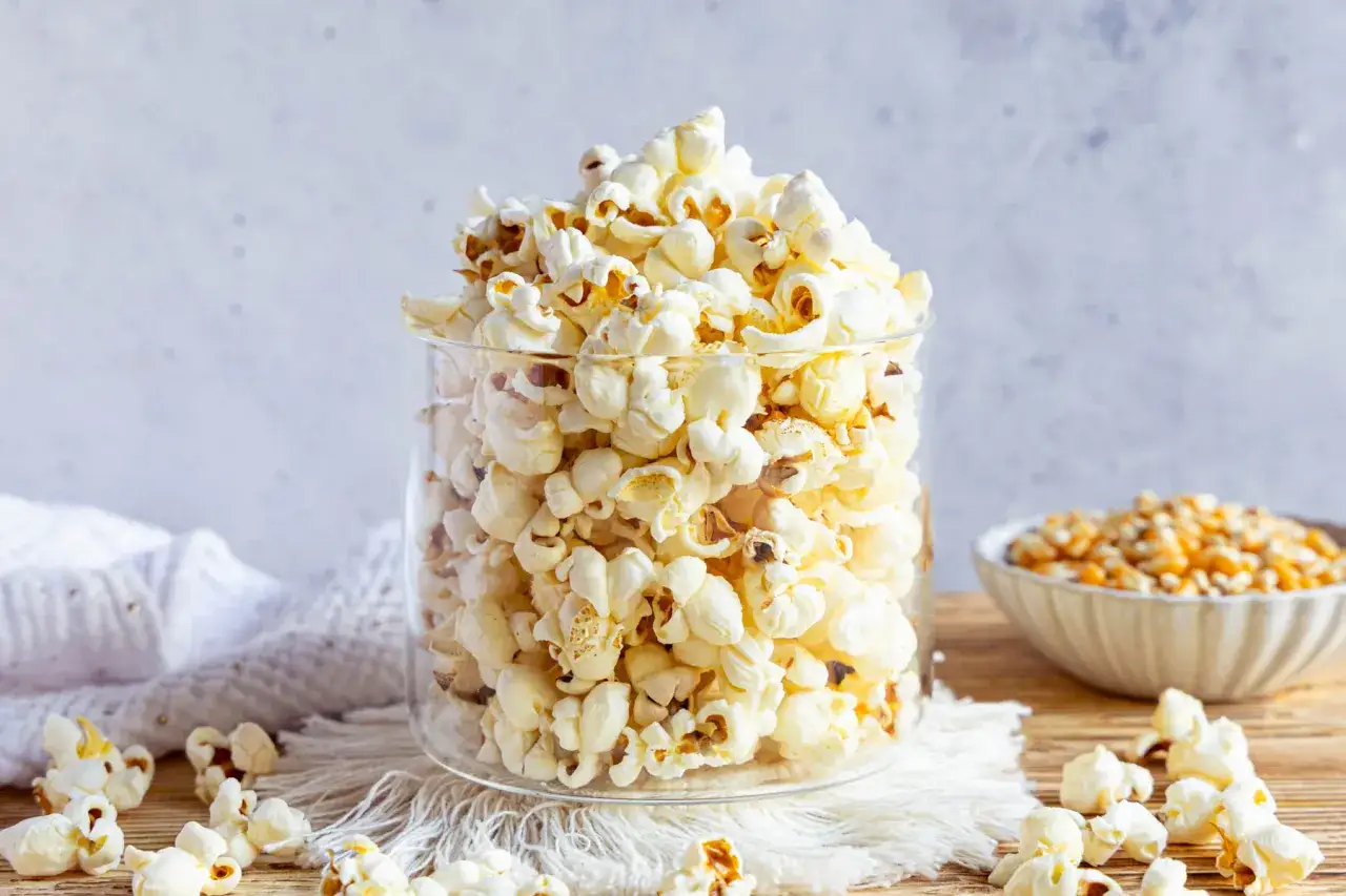 Ein Glas voller frisch gemachtem Popcorn, perfekt für einen Filmabend. So einfach ist Popcorn selber machen!