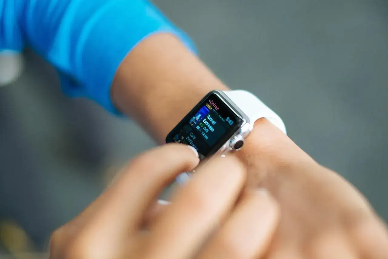 Une personne utilise sa montre connectée pour vérifier des informations. Peut-on téléphoner avec une montre connectée ? Oui, certaines le permettent.