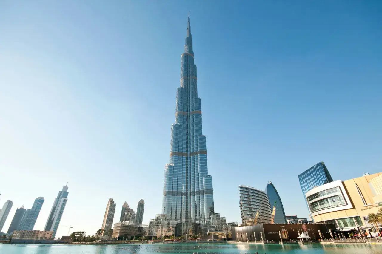 Majestatyczny Burj Khalifa w Dubaju, symbol nowoczesności, góruje nad miastem, odbijając się w spokojnej tafli wody.