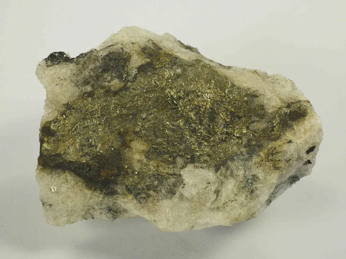 Gestein mit glänzenden, goldfarbenen Pyrit-Kristallen. Vorsicht, Pyrit ist giftig!