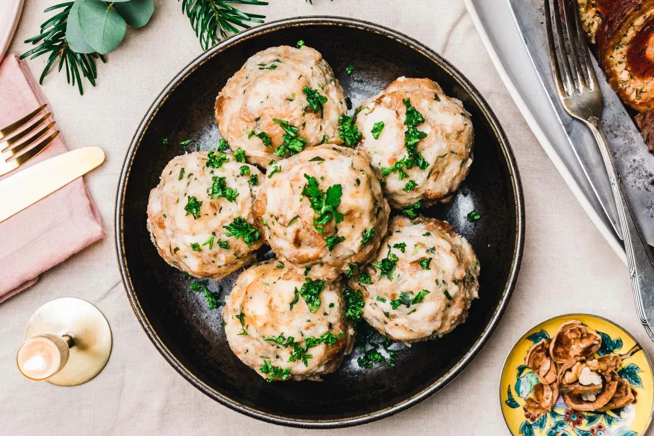Vegane Knödel, garniert mit Petersilie, auf einem Teller. Ein köstliches veganes Knödel Rezept für ein festliches Essen.