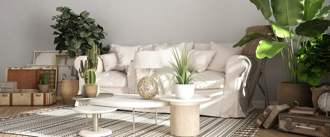 Sofá blanco, plantas, maletas vintage y alfombra geométrica crean un ambiente de **estilo rústico moderno**.