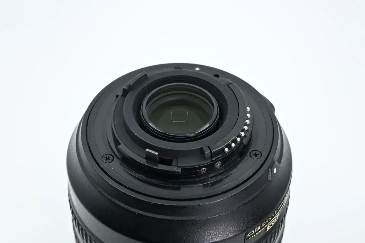 Zbliżenie na mocowanie obiektywu Nikon 18-105mm z widocznymi stykami i elementami optycznymi.