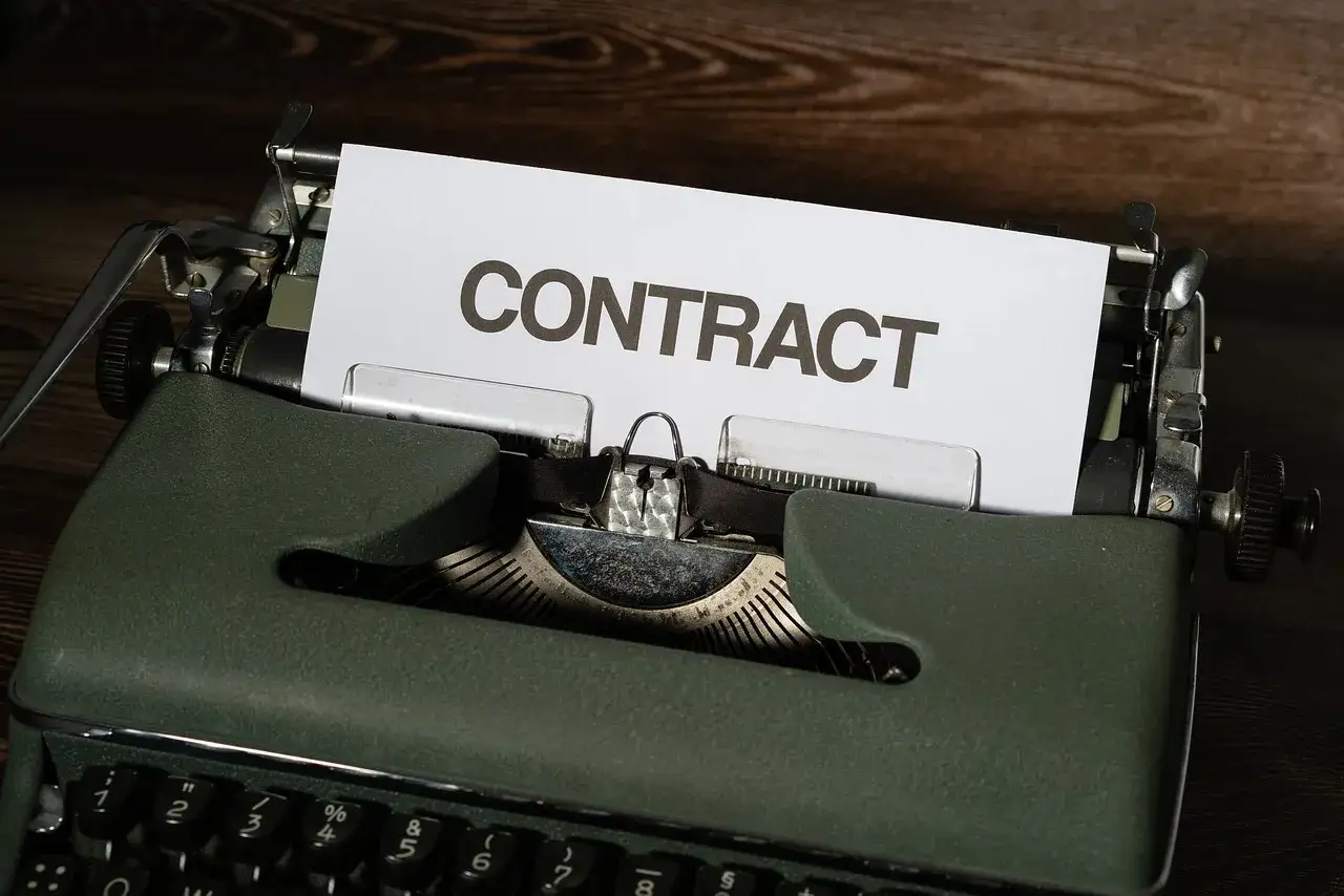 Stara maszyna do pisania z kartką z napisem "CONTRACT". Czas na wypowiedzenie umowy B2B.