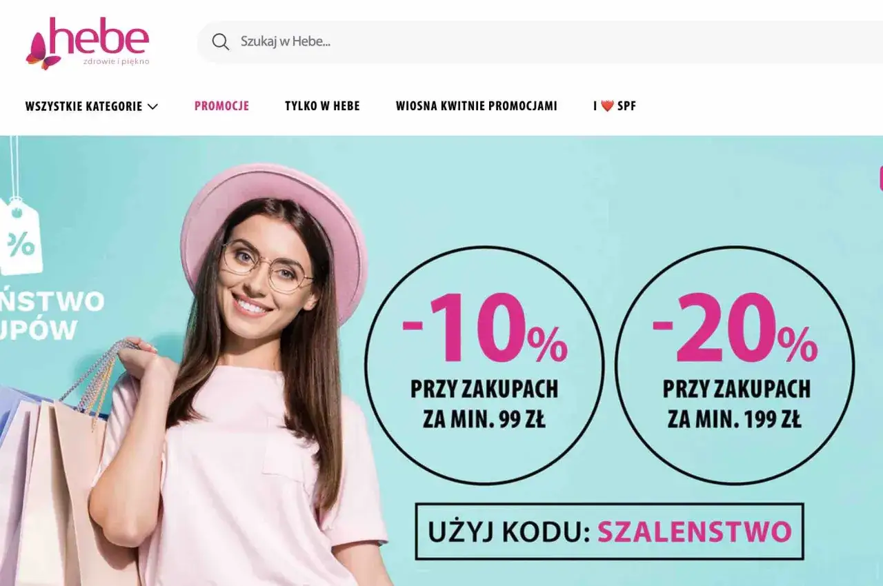 Uśmiechnięta kobieta z torbami na zakupy, promocje -10% i -20% w Hebe.