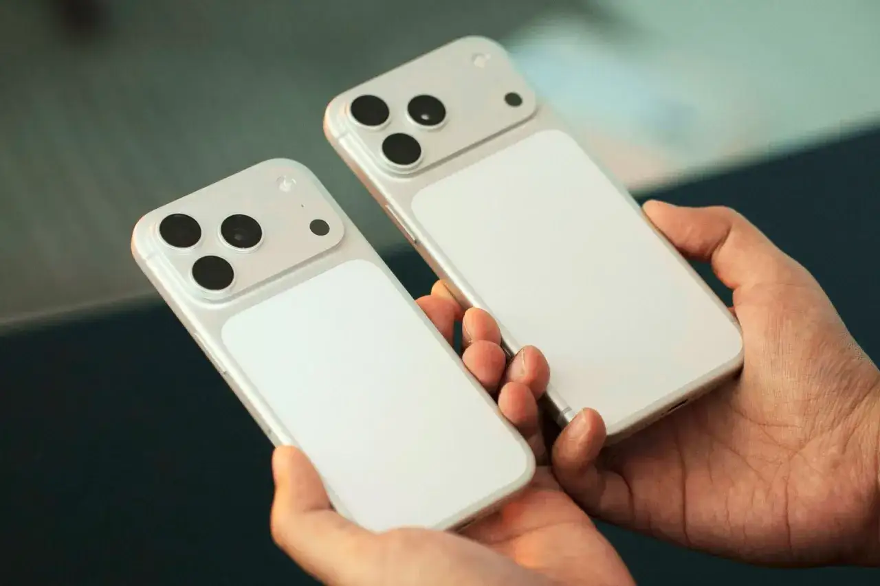 Deux iPhones blancs, prêts pour la sortie du nouvel iPhone, tenus dans des mains.
