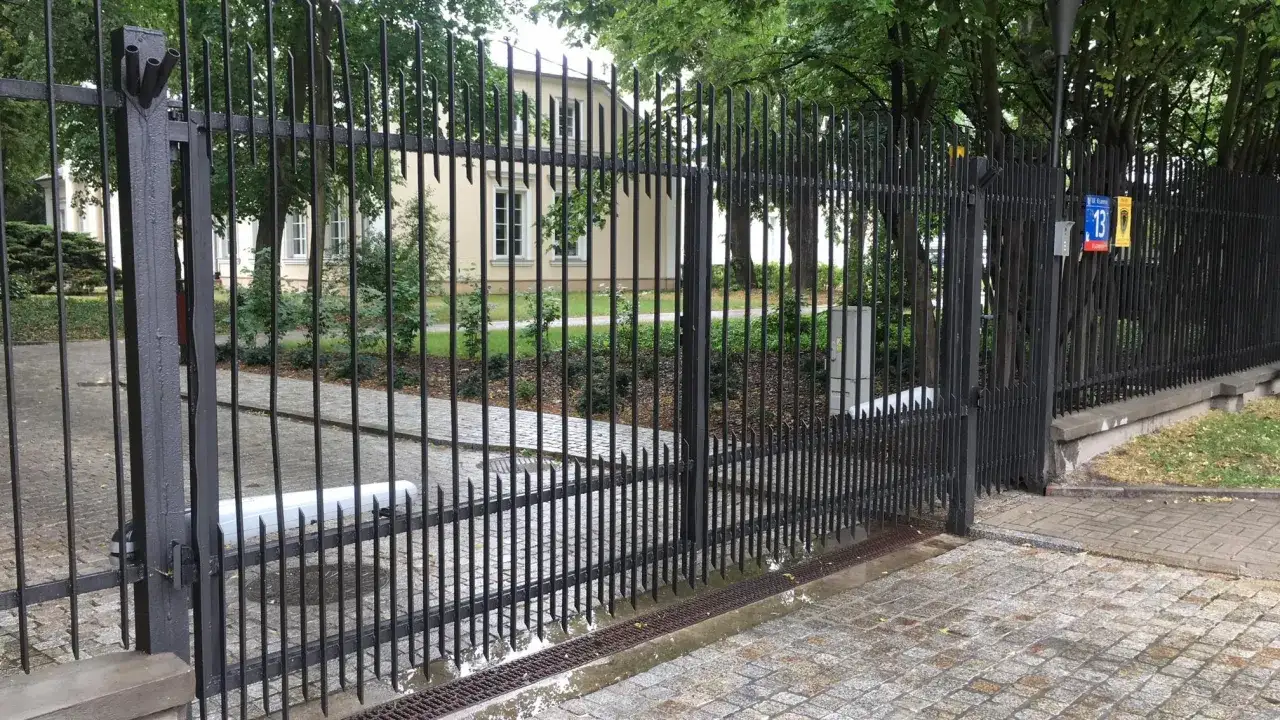 Widoczny mechanizm to jaki napęd do bramy dwuskrzydłowej, zamontowany na jednym ze skrzydeł.