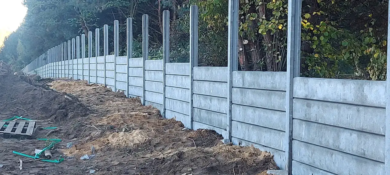Budowa ogrodzenia z betonowych płyt i słupków. Takie słupki betonowe to solidna podstawa.