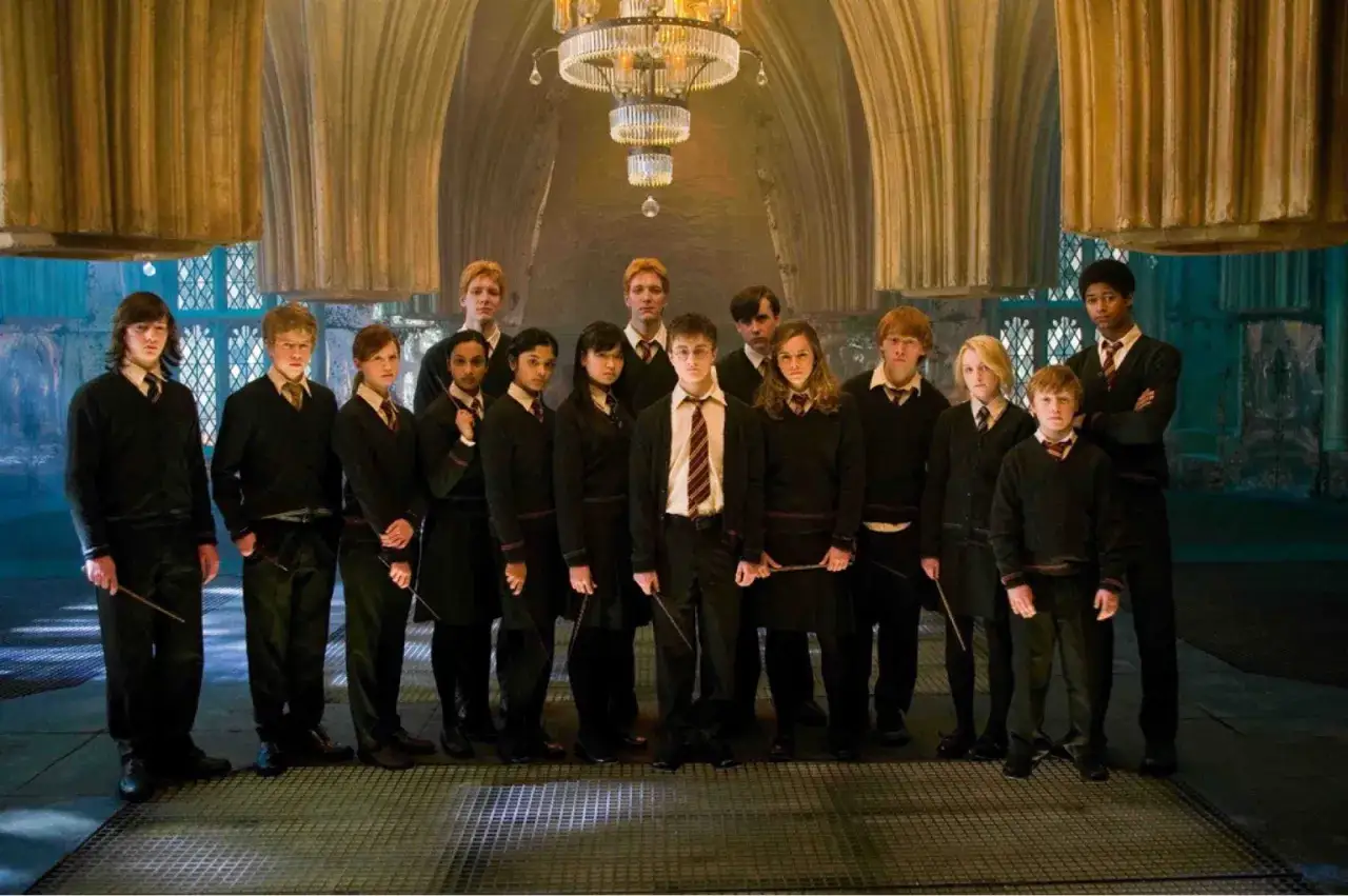 Grupa uczniów z domu Hufflepuff, w tym Harry Potter, stoi w eleganckiej sali.