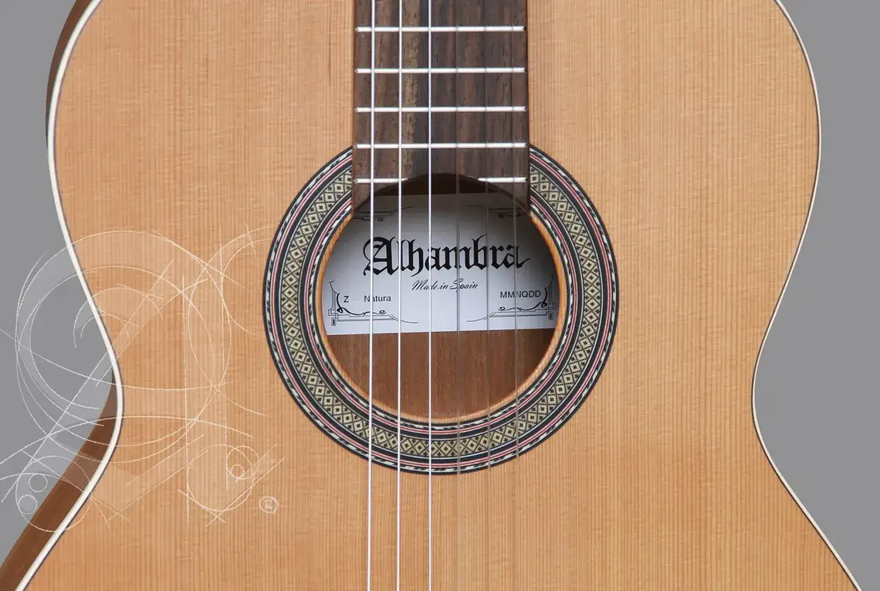Gitara Alhambra z serii Natura, wykonana z naturalnego drewna, z ozdobnym rozetą i białymi, delikatnymi liniami przypominającymi szkice.