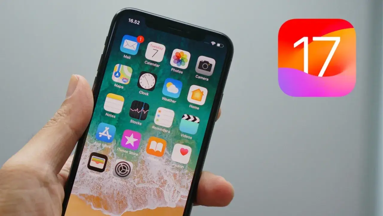Dłoń trzyma iPhone'a z ikonami aplikacji, obok widnieje logo iOS 17.