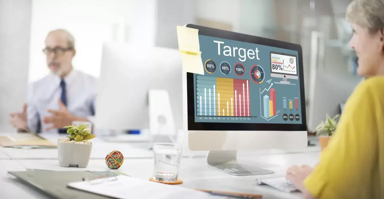 Kobieta analizuje wykresy na ekranie komputera, planując kampanię reklamową w internecie.