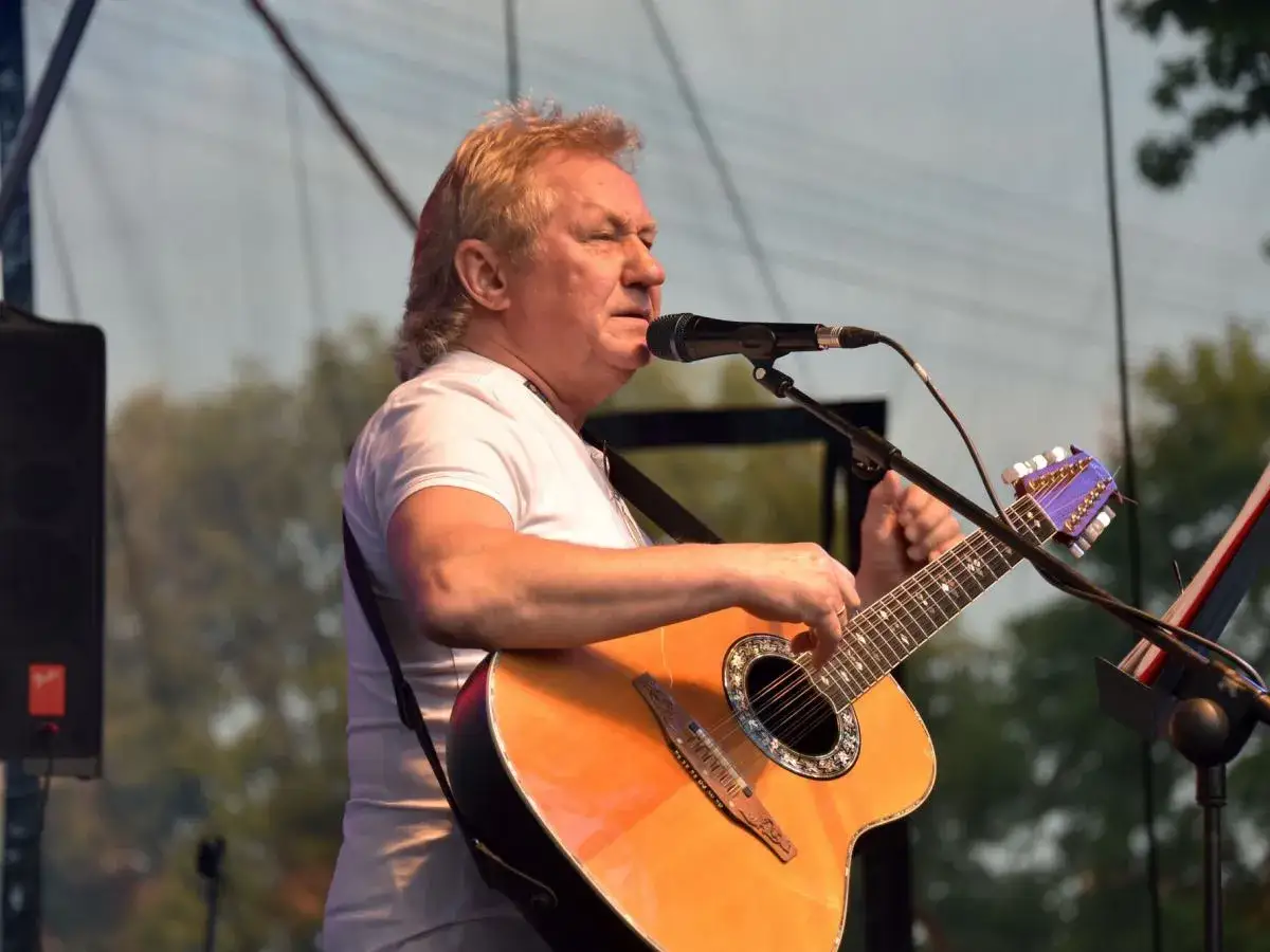 Janusz Laskowski śpiewa i gra na gitarze podczas kolorowych jarmarków.