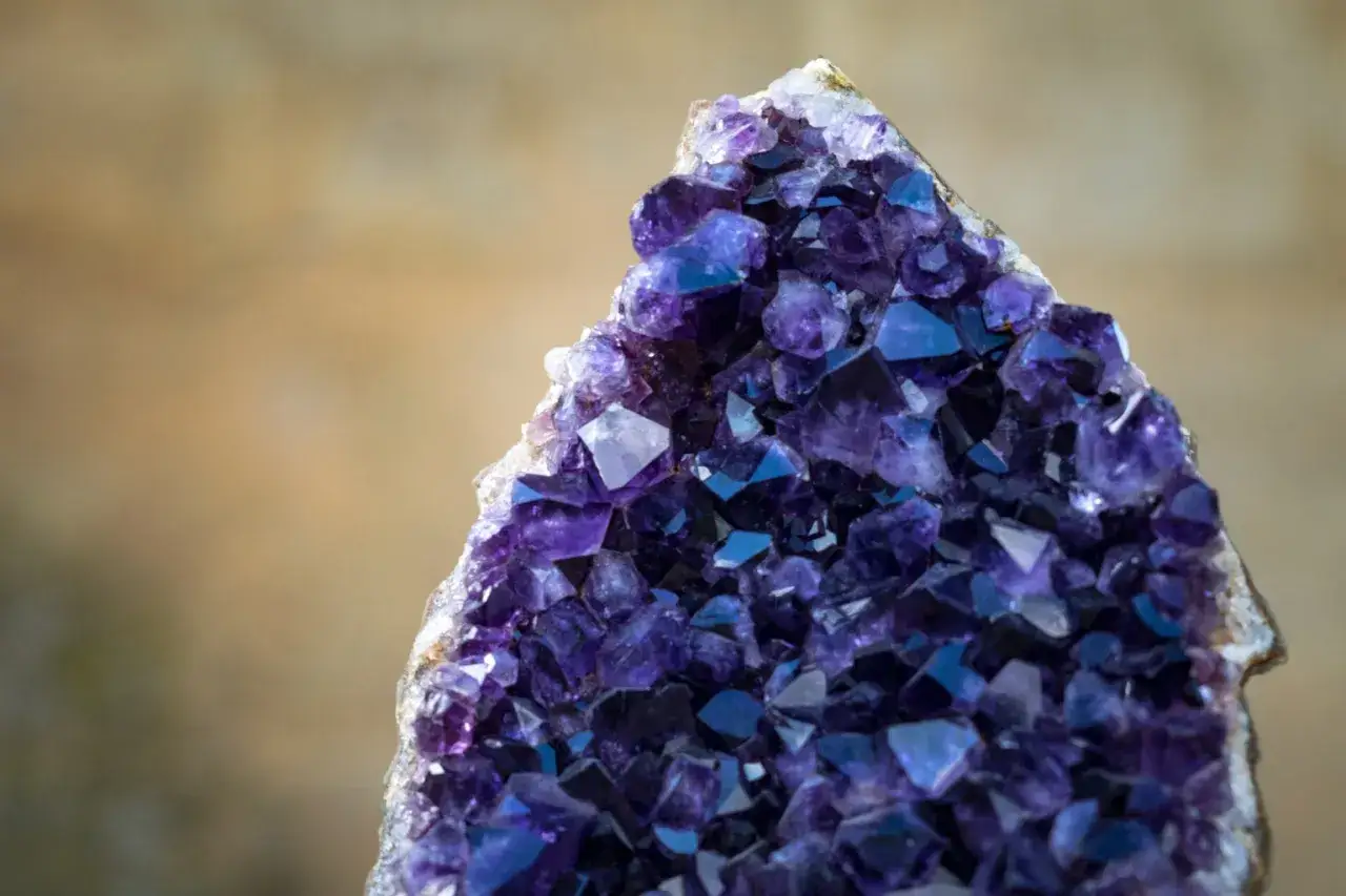 Ein glitzernder Amethyst Edelstein mit tiefvioletten Kristallen, der wie ein Schatz aus einer anderen Welt wirkt.