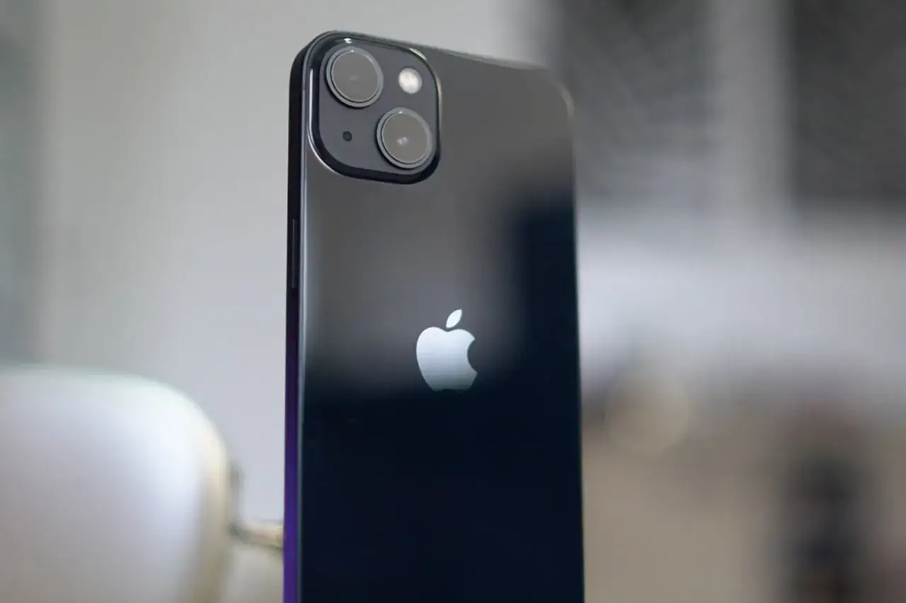 Arrière d'un iPhone 13, avec son logo Apple et le module photo incluant un objectif grand angle.
