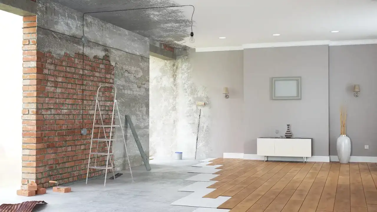 Renovación de casas con encanto: ladrillo visto, escalera, rodillo y suelo de madera en proceso.