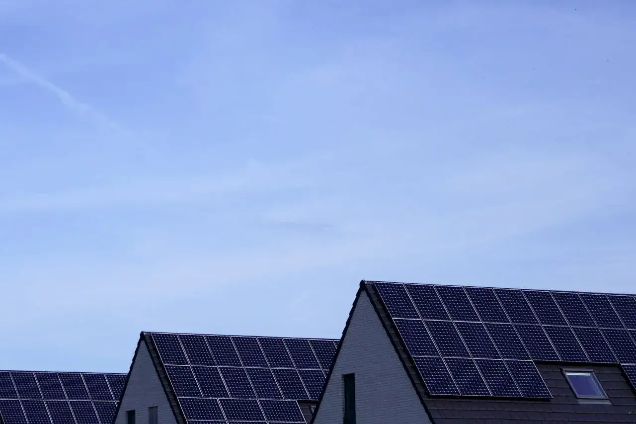 Dachy domów pokryte panelami fotowoltaicznymi. Stabilizator napięcia fotowoltaika zapewnia optymalną pracę instalacji.