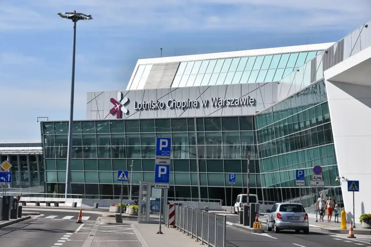 Nowoczesny budynek Lotniska Chopina w Warszawie. Znak "Koniec" i parkingowe wskazują, jak dojechać na lotnisko Chopina.