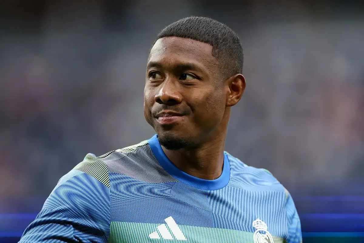 Piłkarz David Alaba w niebieskiej koszulce z białym logo Adidas i herbem Realu Madryt.
