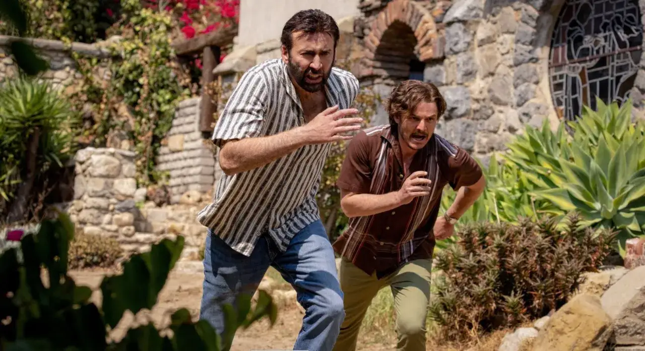 Dwóch mężczyzn biegnie, ich twarze wyrażają panikę. Nicolas Cage, z nieznośnym ciężarem wielkiego talentu, ucieka przed czymś nieznanym.