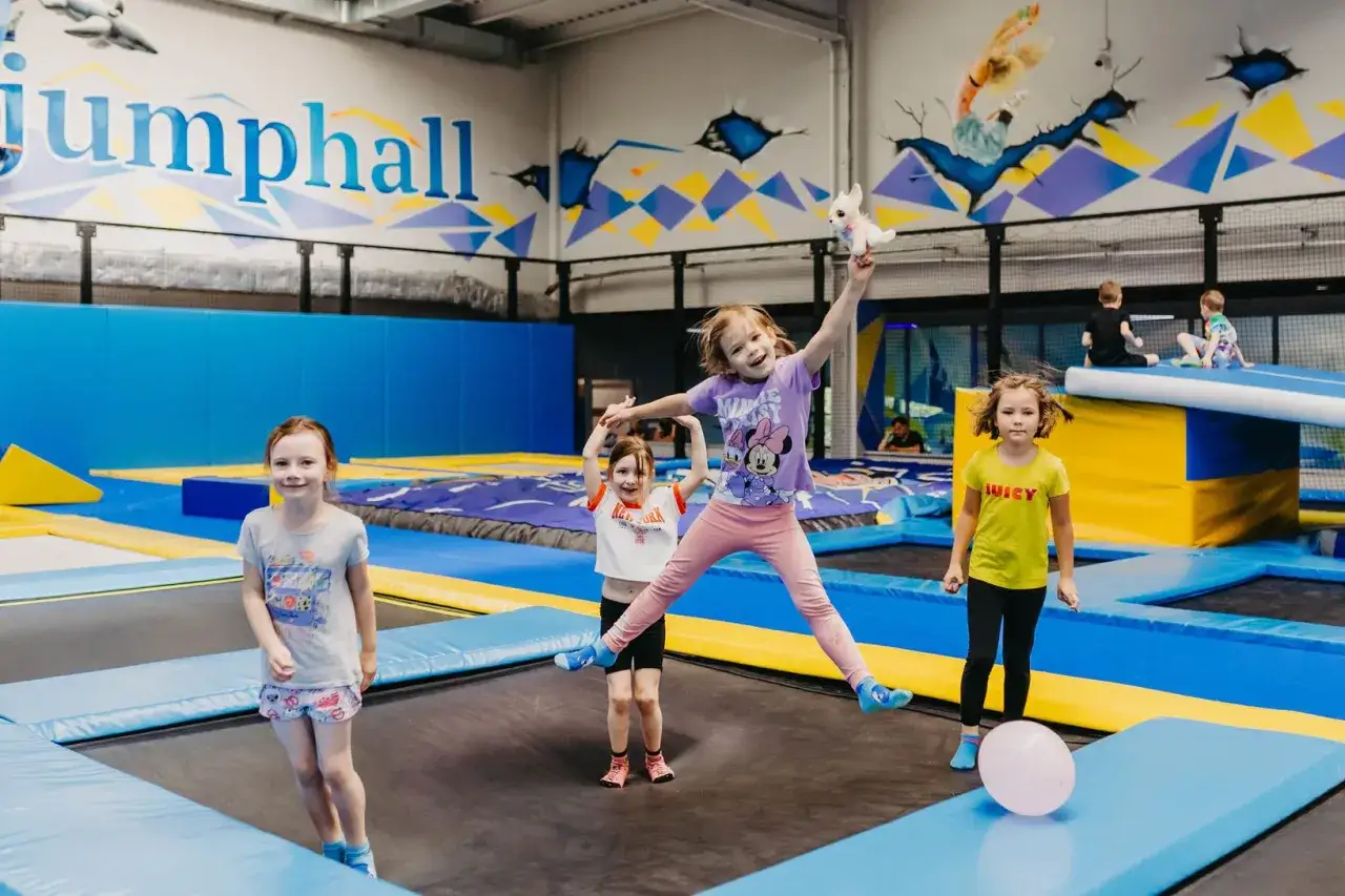 Dzieci skaczą na trampolinach w sali zabaw. Czy trampolina jest zdrowa? Zdecydowanie tak, to świetna zabawa i aktywność fizyczna!