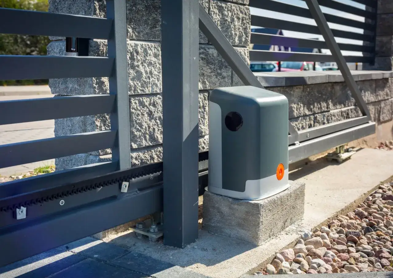 Napęd do bramy przesuwnej zamontowany na fundamencie. Zobacz, jak zamontować zamek do bramy przesuwnej, by zapewnić bezpieczeństwo.